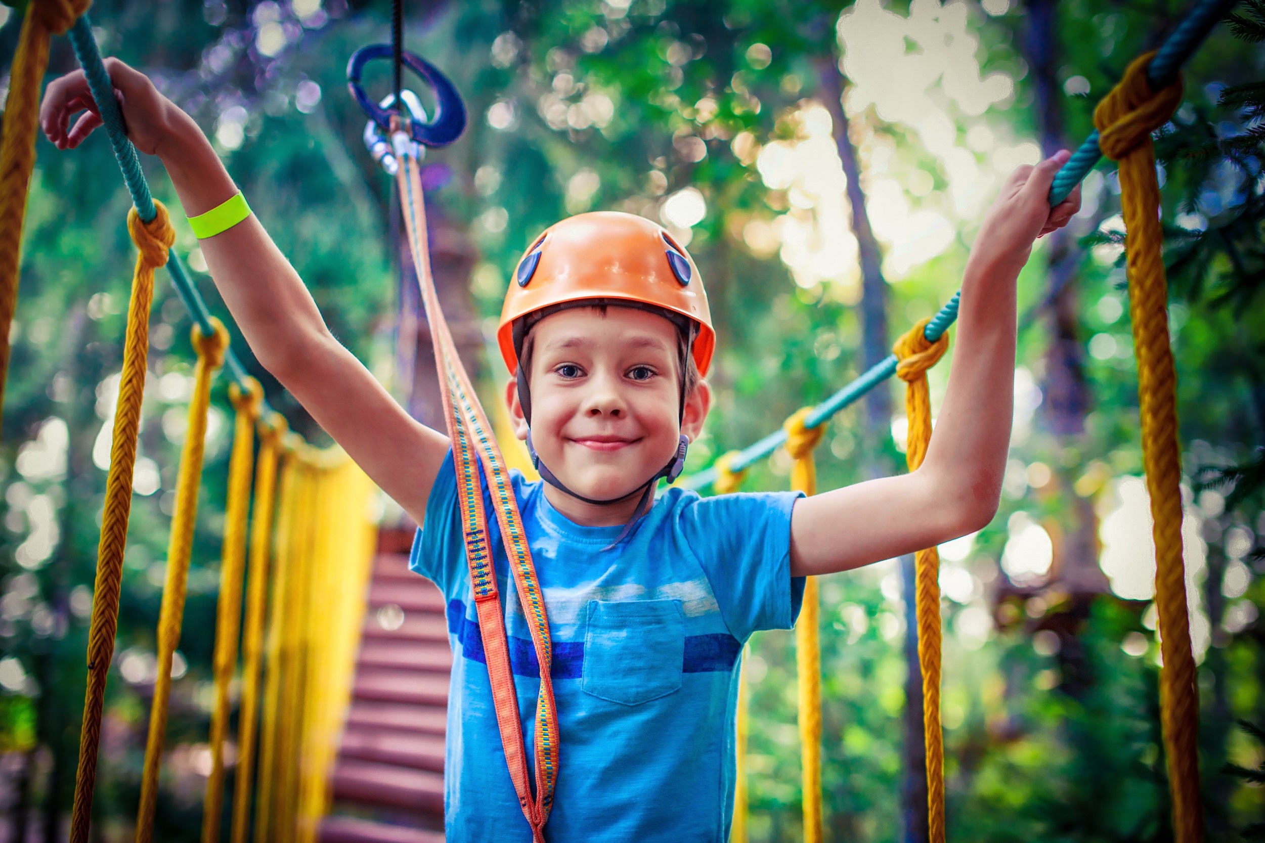 boy on rope course with helmet on